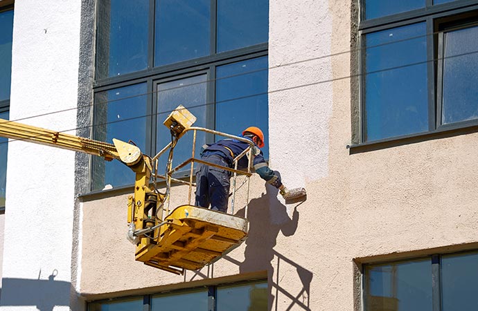 professional worker painting extorior of a commercial building
